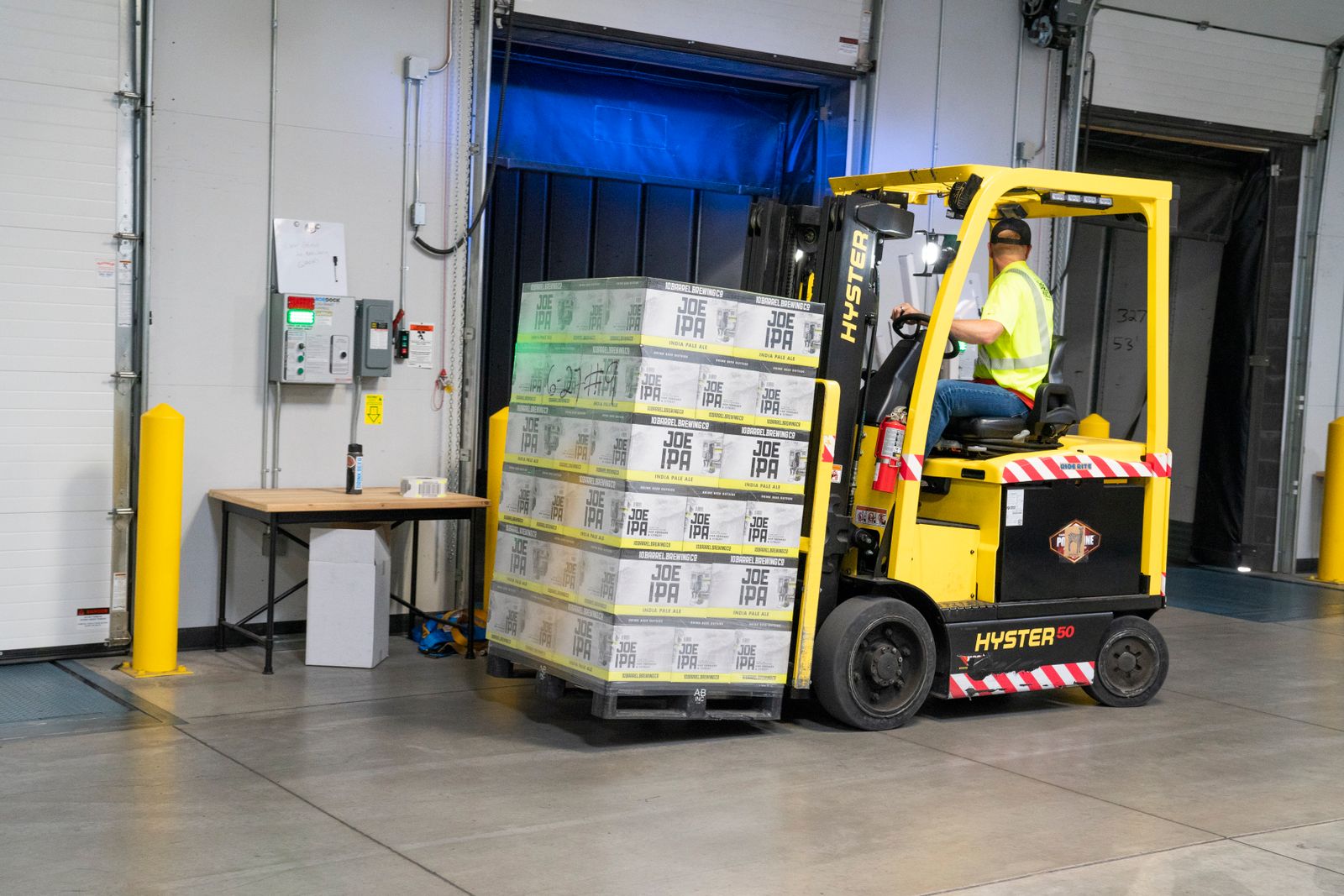 Forklift operator moving palletized freight in a distribution warehouse